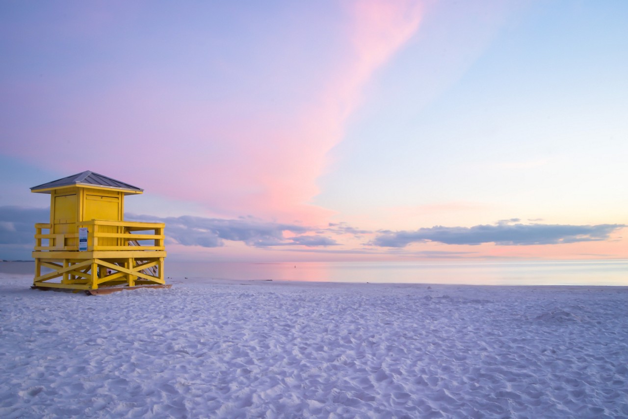 Family with surf boards running on beach while on a Florida vacation
