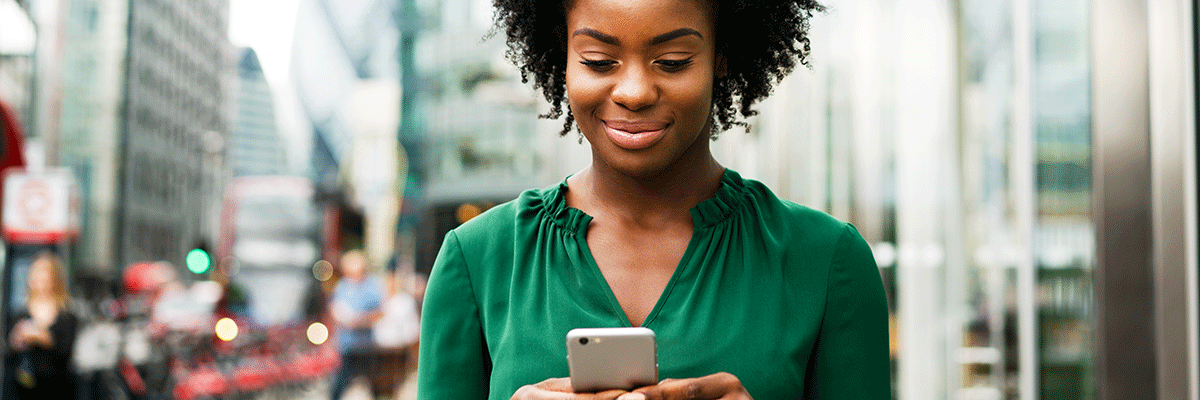 Woman using smart phone in city.