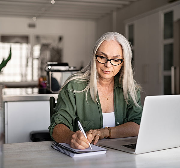 Woman on cell phone holding tax forms